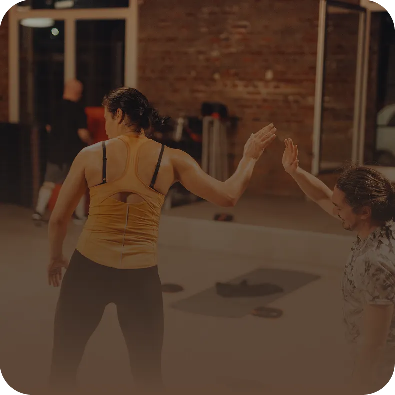 Zwei Mitglieder geben sich High-Five nach dem Training im Peoples Fitness Studio – Community und Motivation